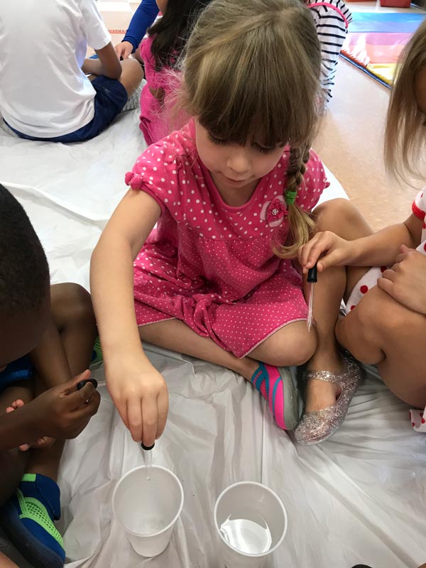 A child doing a science experiment at a Greenville, NC Child development center