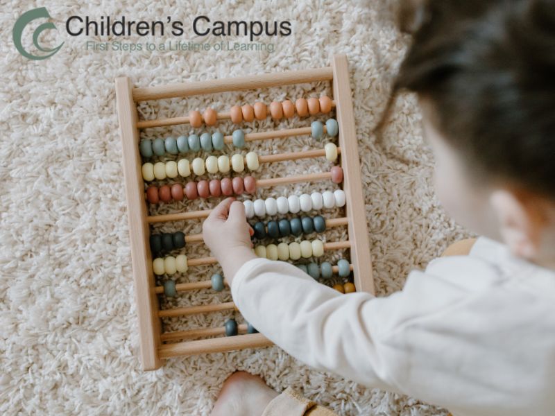 Child using an abacus to learn early math skills through STEM play at Children’s Campus Greenville.